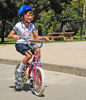 girl riding bike wearing helmet